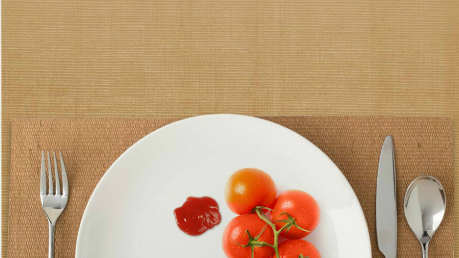 Tomates e ketchup em prato com talheres