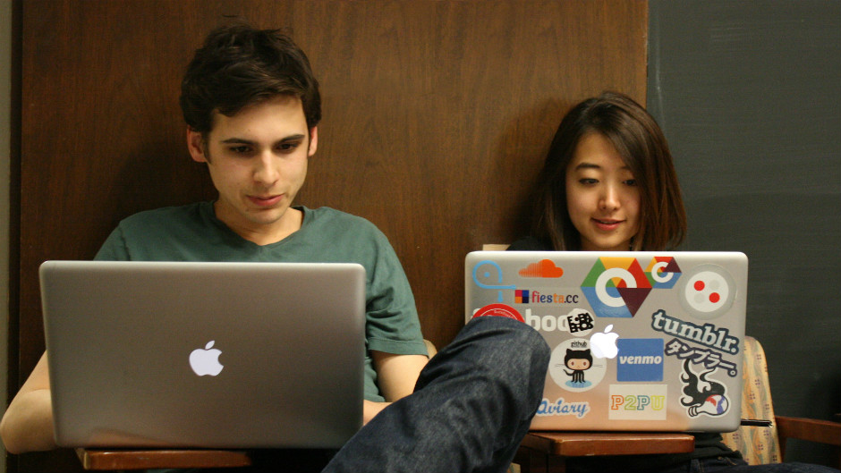 Jovem homem e jovem mulher asiática trabalham com laptops sentados no chão