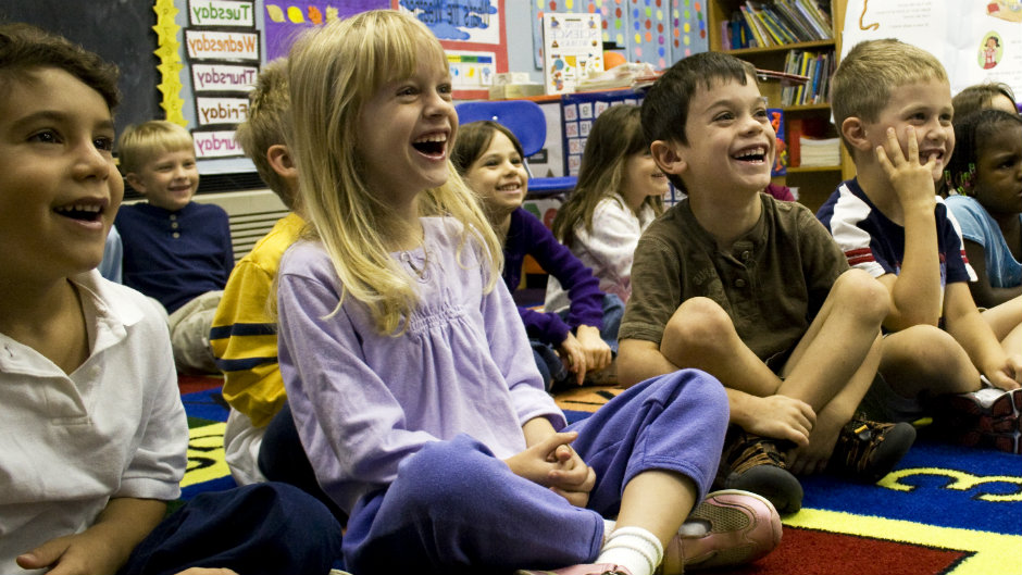 crianças rindo em sala de aula