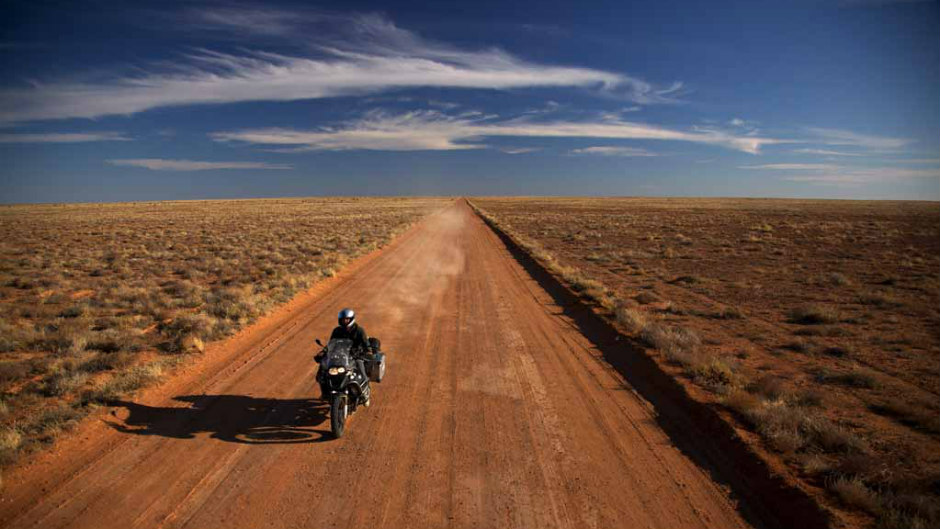 Homem andando de moto no deserto