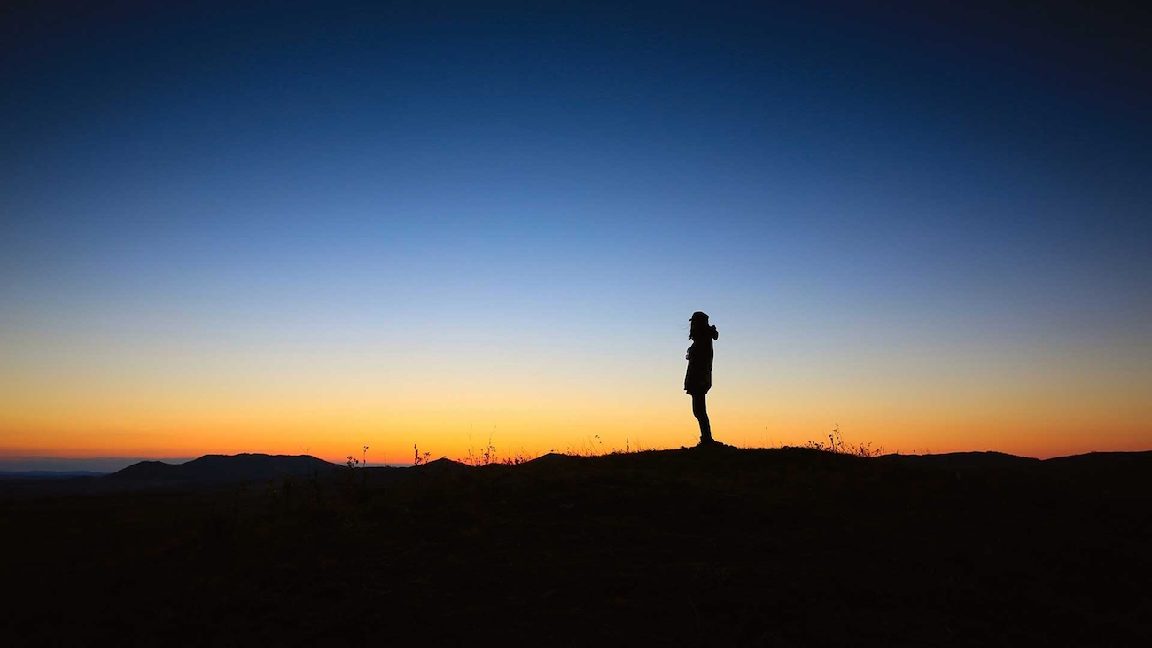 Silhueta de pessoa sozinha observando o nascer do sol – O que é autoliderança?