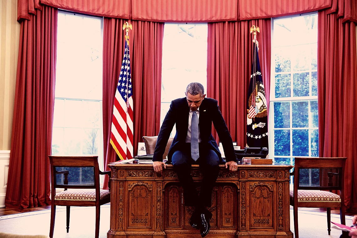 Barack Obama sentado na mesa de escritório da Casa Branca