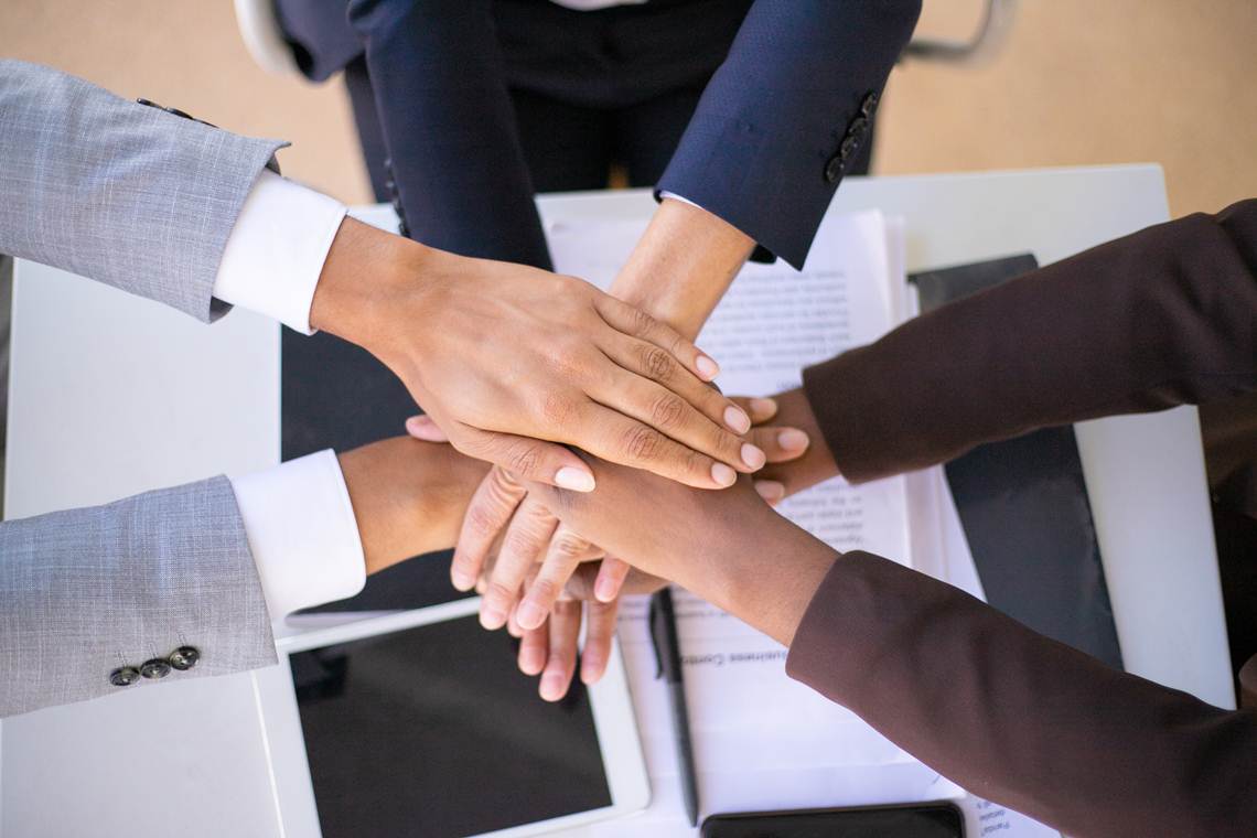 Business team showing unity Relacionamento interpessoal no trabalho