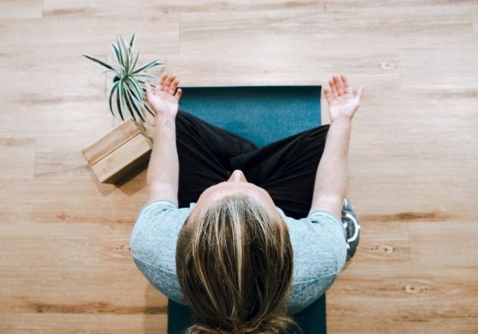 pessoa com cabelos loiros praticando meditação - um momento de mindfulness - vista de cima